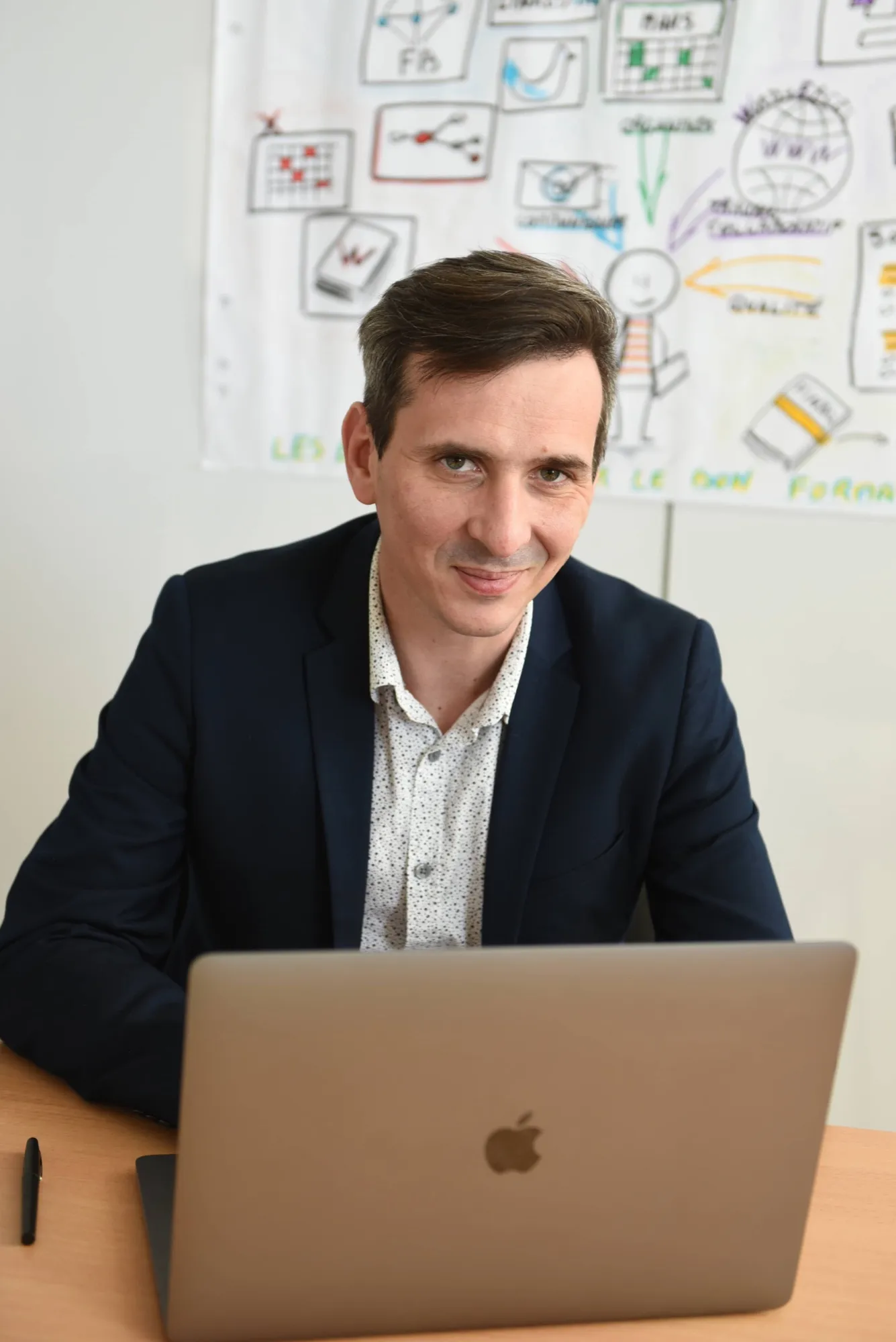 Jérémy Sarda, formateur Millorem, à son bureau devant un tableau de schémas de formation